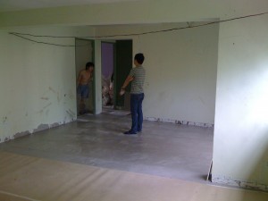 Living room tiles nearly complete, half covered in protective paper. Living room tiles nearly complete, half covered in protective paper.